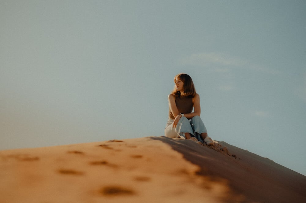 Example of correctly exposed image woman siting on sand dune
